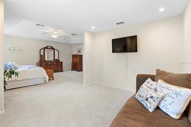 bedroom with ceiling fan, a tray ceiling, and light carpet