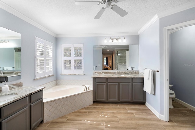 full bathroom featuring vanity, ornamental molding, toilet, and a textured ceiling