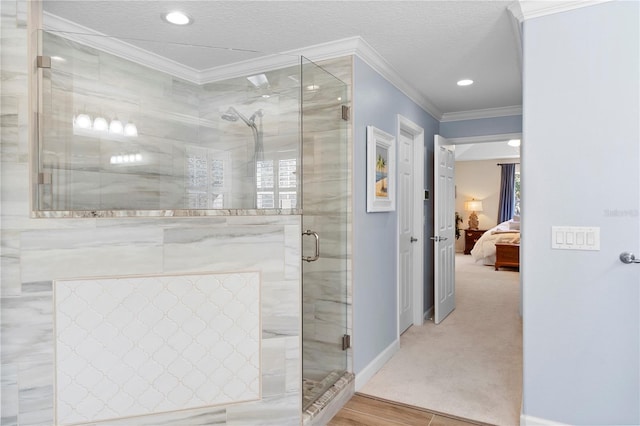 bathroom with ornamental molding, a shower with shower door, hardwood / wood-style floors, and a textured ceiling