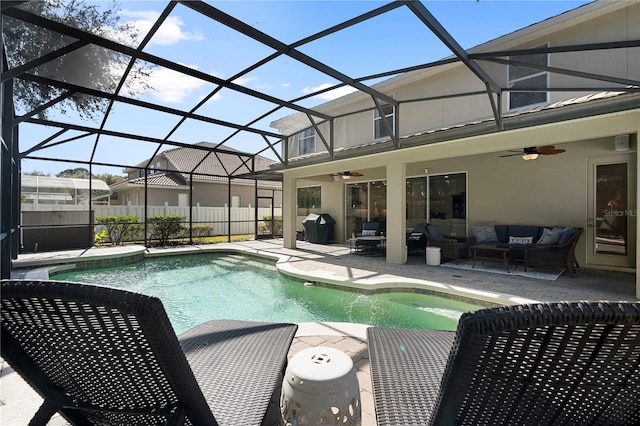 view of pool featuring outdoor lounge area, a patio, ceiling fan, and glass enclosure