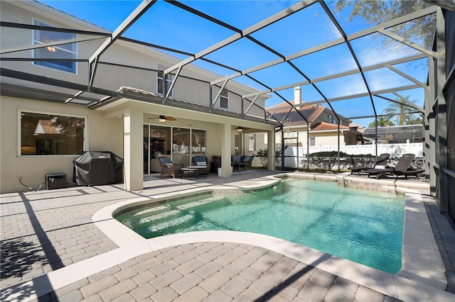 view of swimming pool featuring a grill, a patio area, ceiling fan, and glass enclosure