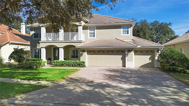 view of front of house with a garage, a balcony, and a front yard