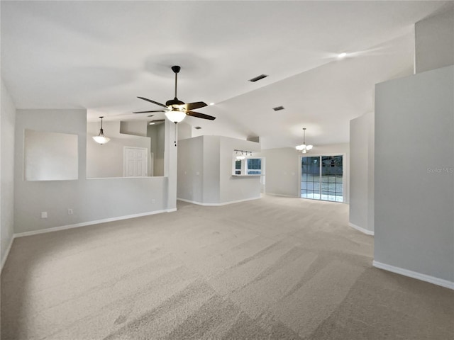 unfurnished living room featuring ceiling fan with notable chandelier, carpet flooring, and vaulted ceiling