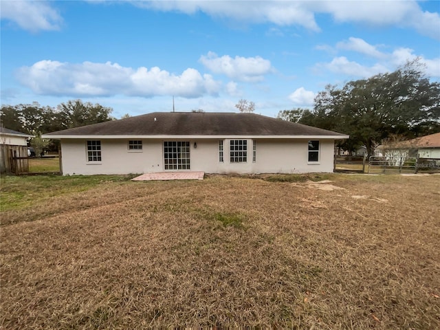 rear view of property with a lawn