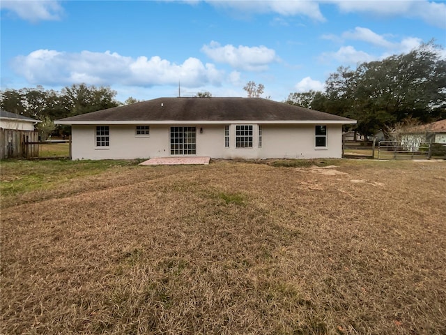 back of property with a lawn