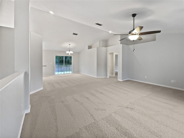 unfurnished living room featuring ceiling fan with notable chandelier, light colored carpet, and vaulted ceiling