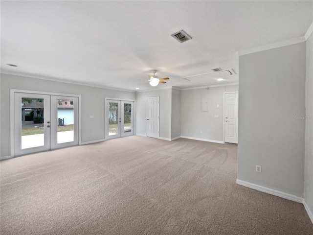 carpeted spare room with ornamental molding, ceiling fan, and french doors