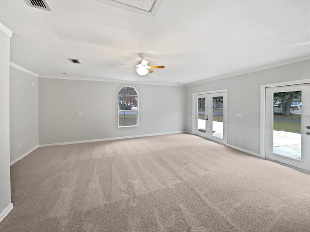 carpeted empty room with french doors, a healthy amount of sunlight, and crown molding