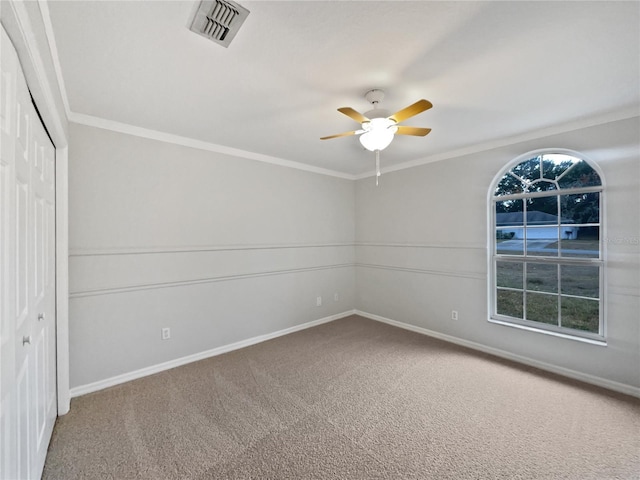 carpeted spare room with ceiling fan and ornamental molding