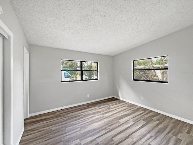 unfurnished bedroom with a textured ceiling and light wood-type flooring