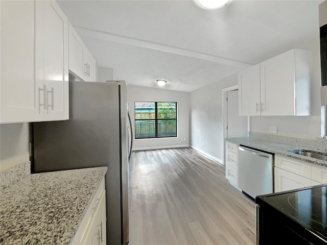 kitchen featuring appliances with stainless steel finishes, white cabinets, sink, light hardwood / wood-style flooring, and light stone counters