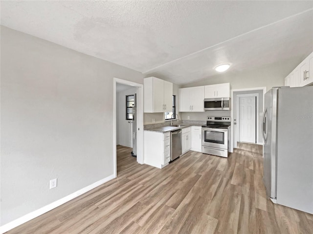 kitchen with sink, white cabinetry, a textured ceiling, and appliances with stainless steel finishes