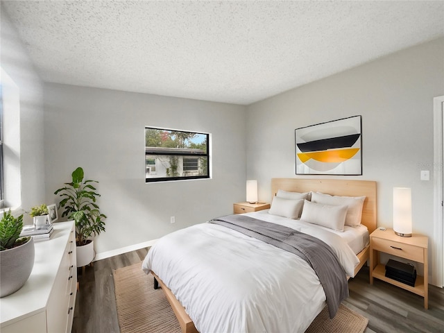 bedroom featuring a textured ceiling and dark hardwood / wood-style floors