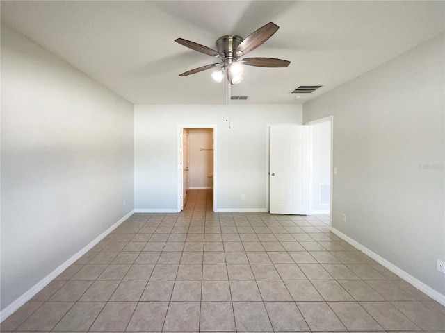 empty room with ceiling fan and light tile patterned floors