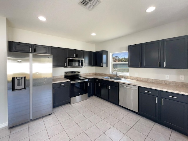 kitchen with sink, stainless steel appliances, and light tile patterned flooring