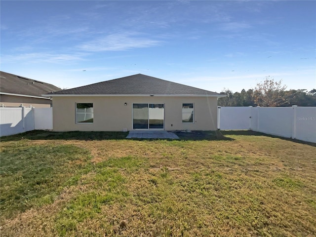 rear view of house featuring a yard