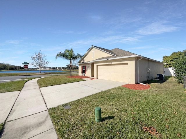 ranch-style home with a garage, a water view, and a front yard