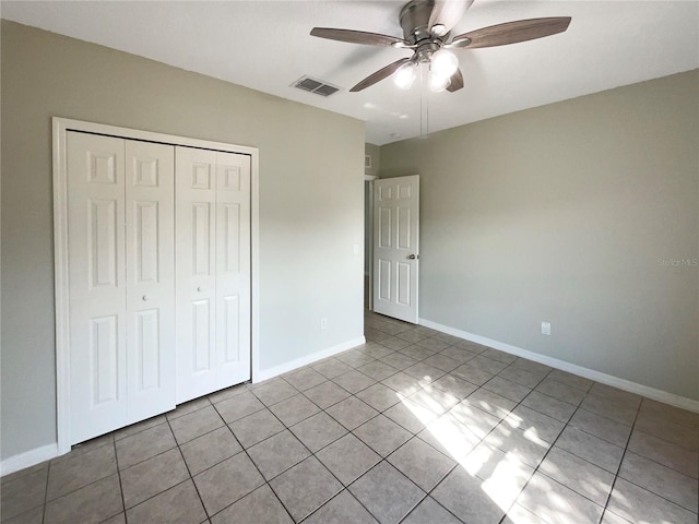 unfurnished bedroom with light tile patterned flooring, a closet, and ceiling fan