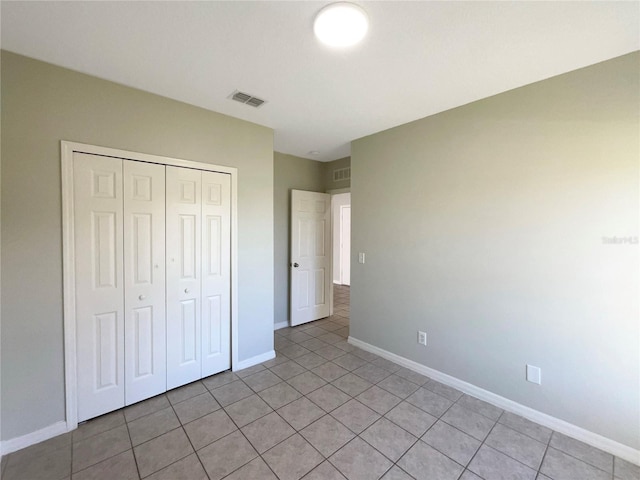 unfurnished bedroom featuring a closet and light tile patterned flooring