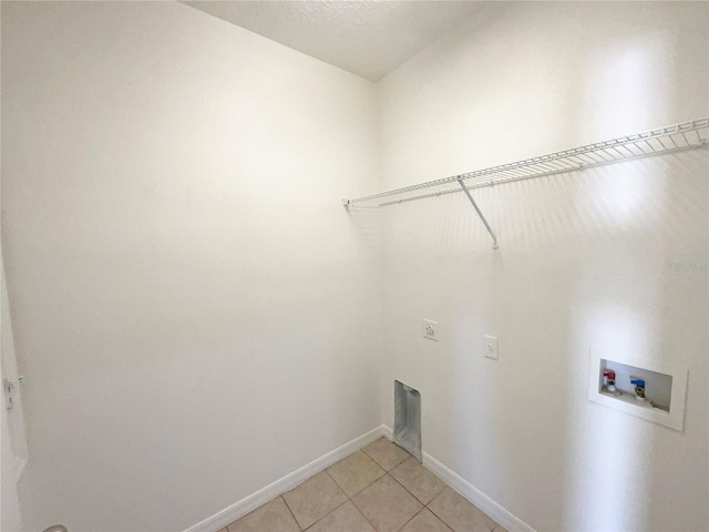 washroom featuring a textured ceiling, electric dryer hookup, washer hookup, and light tile patterned floors