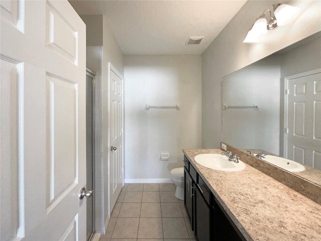 bathroom featuring a textured ceiling, tile patterned floors, vanity, and toilet