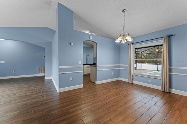 spare room with a notable chandelier, vaulted ceiling, and a textured ceiling