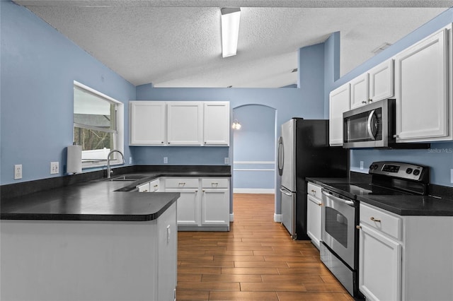 kitchen with sink, white cabinets, kitchen peninsula, stainless steel appliances, and a textured ceiling