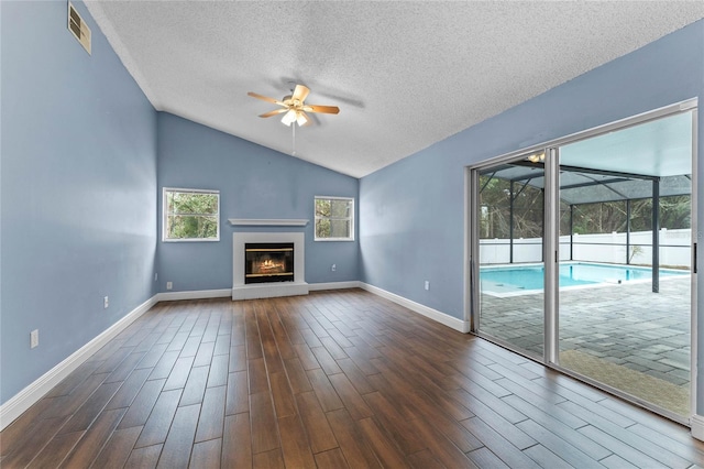 unfurnished living room with ceiling fan, lofted ceiling, and a textured ceiling