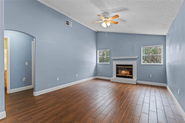 unfurnished living room with ceiling fan, lofted ceiling, a textured ceiling, and a wealth of natural light