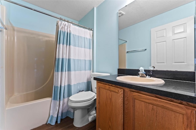 full bathroom with toilet, a textured ceiling, vanity, shower / bath combo with shower curtain, and hardwood / wood-style floors