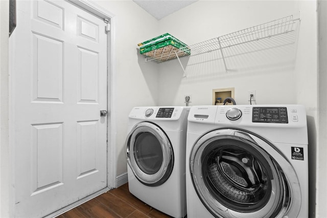 clothes washing area featuring dark wood-type flooring, washer and clothes dryer, and a textured ceiling