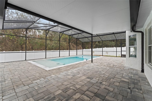 view of swimming pool featuring a patio and glass enclosure