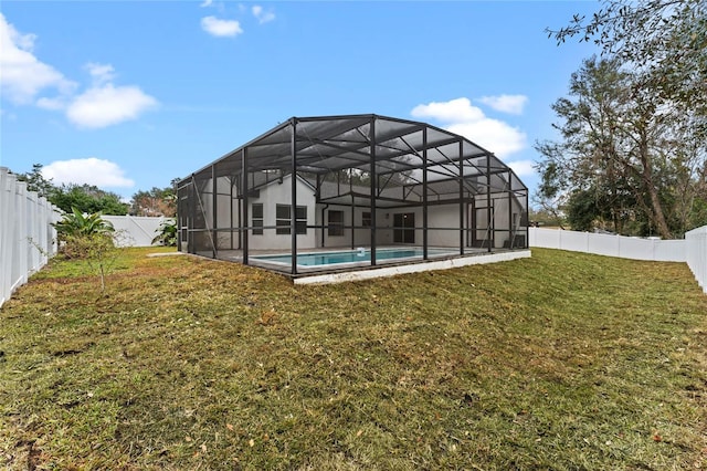 back of property featuring a fenced in pool, a yard, and a lanai