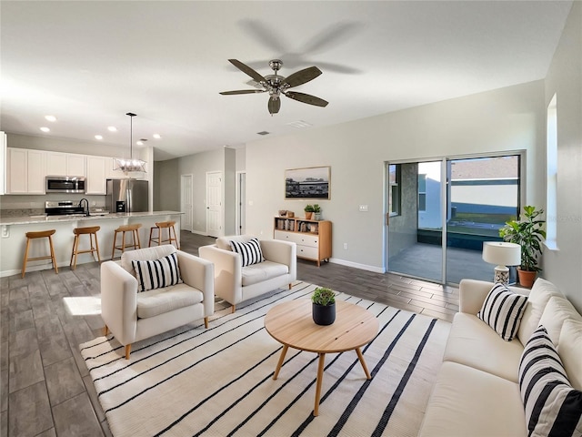 living room featuring ceiling fan with notable chandelier