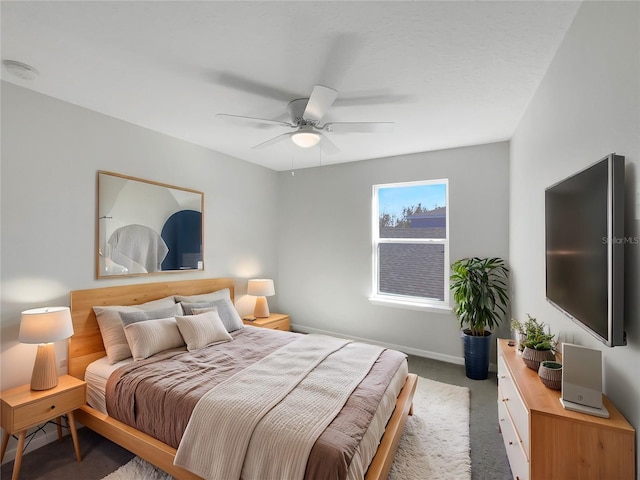 bedroom featuring ceiling fan and dark carpet