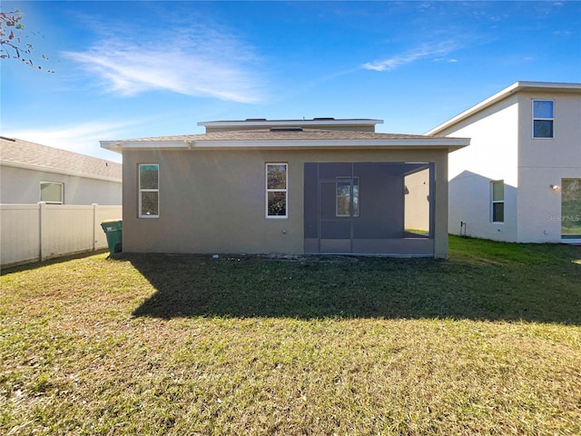 back of house with a yard and a sunroom