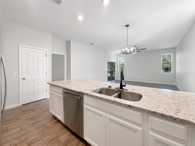 kitchen with white cabinets, dishwasher, sink, and light stone counters