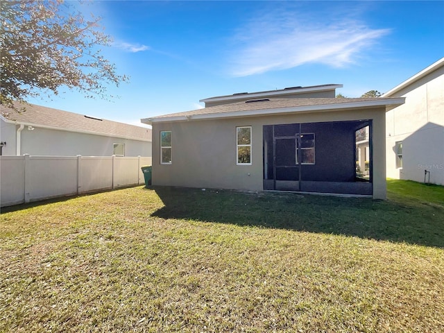 rear view of house featuring a yard