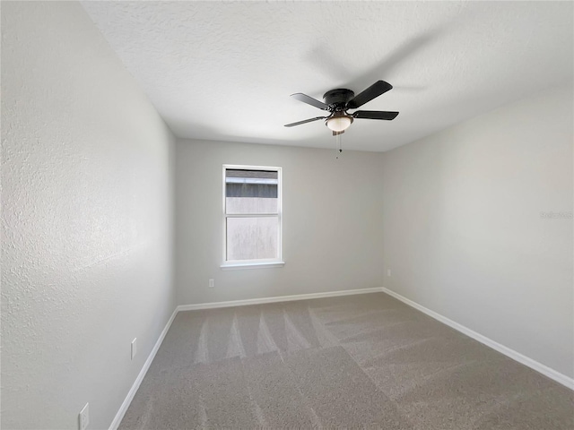 spare room with a textured ceiling, ceiling fan, and carpet