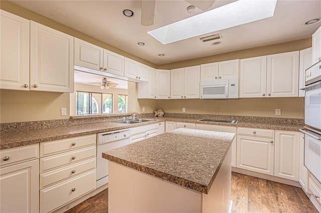 kitchen with white cabinetry, white appliances, a center island, and ceiling fan