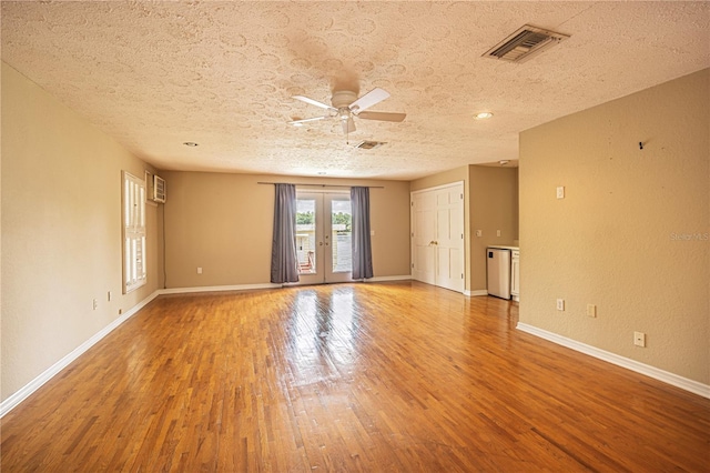 unfurnished room featuring ceiling fan, wood-type flooring, french doors, and a textured ceiling