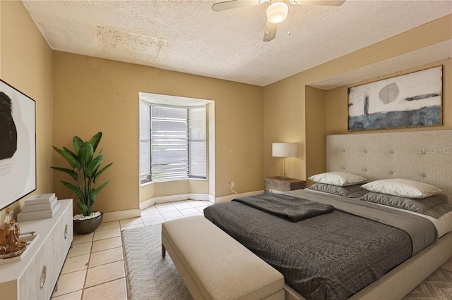 tiled bedroom with ceiling fan and a textured ceiling