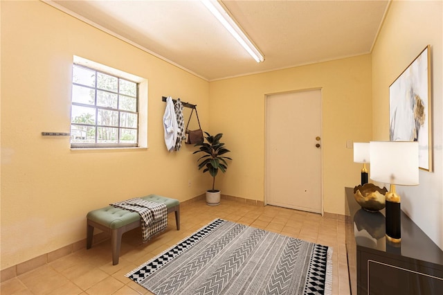 sitting room featuring crown molding and light tile patterned floors