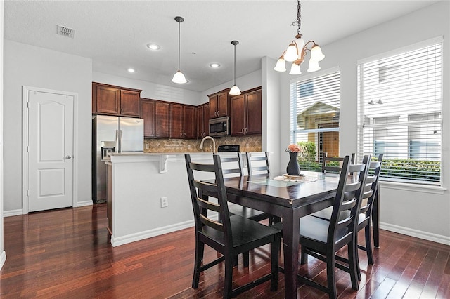 dining room featuring dark hardwood / wood-style flooring and a chandelier