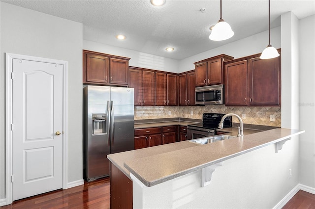 kitchen featuring decorative backsplash, kitchen peninsula, pendant lighting, a breakfast bar, and stainless steel appliances