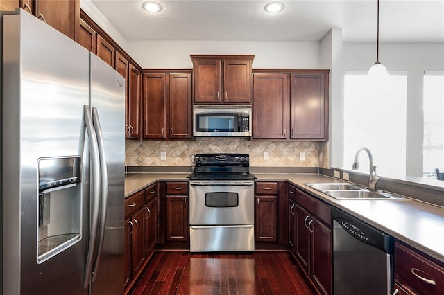 kitchen featuring decorative backsplash, sink, hanging light fixtures, and appliances with stainless steel finishes