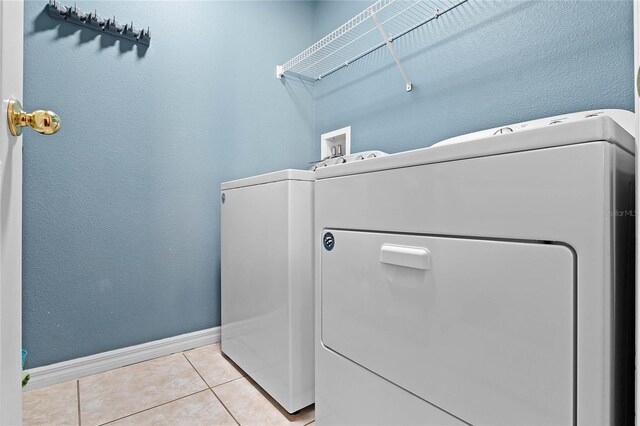 laundry area featuring washer and dryer and light tile patterned flooring