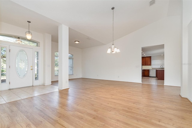 foyer entrance with a chandelier, visible vents, a healthy amount of sunlight, and light wood-style floors