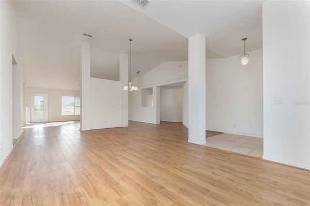 unfurnished living room featuring vaulted ceiling, a notable chandelier, visible vents, and light wood finished floors