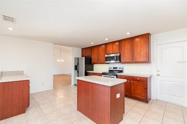 kitchen with visible vents, a kitchen island, light tile patterned flooring, appliances with stainless steel finishes, and backsplash